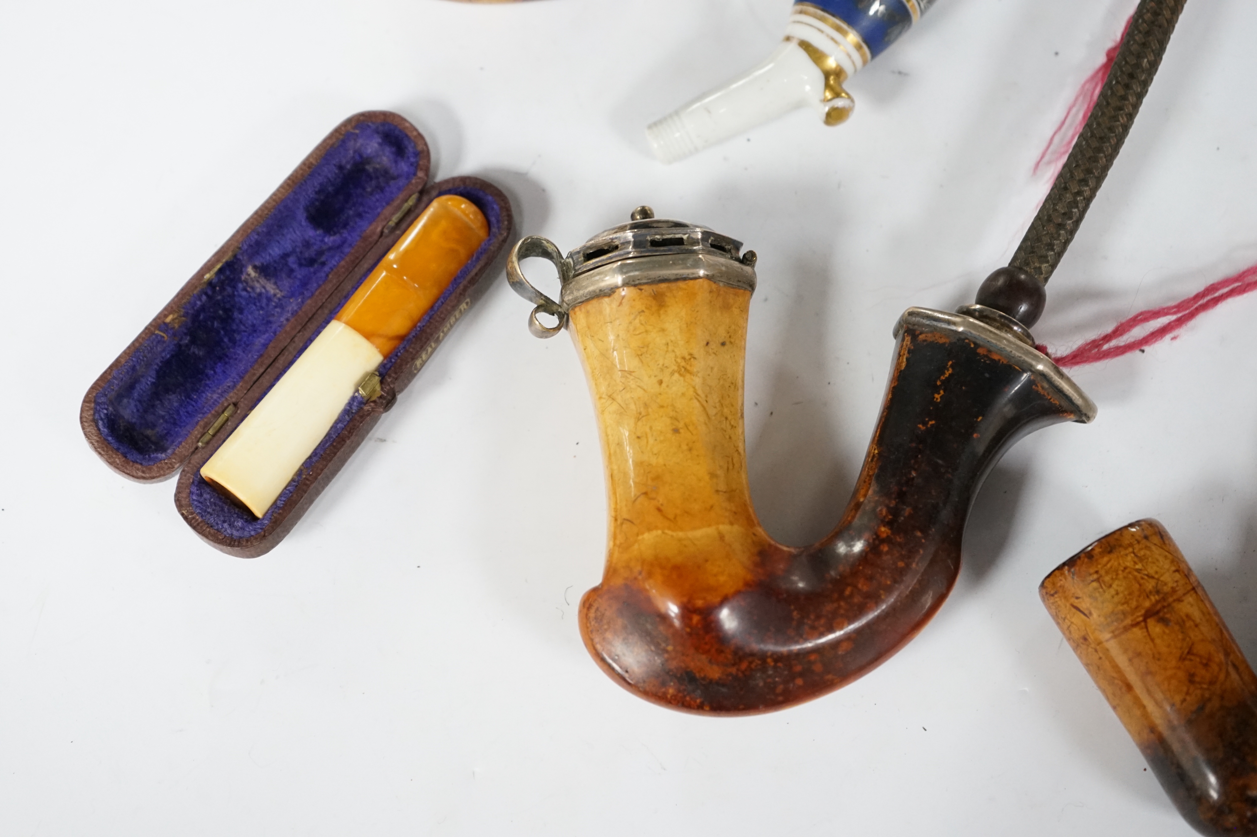 Seven pipes, three with amber mouthpieces, two cased and two without mouthpieces, longest cased pipe 20cm long